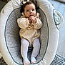animal, baby, canine, clothing, crib, face, furniture, head, hosiery, infantbed, person, pet, sock