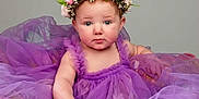 Lillian is registered to the contest to win money with this photo: baby, child, purple_tutu, flower_crown, portrait, cute, studio_photo, infant, soft_lighting, dress, tulle, headwear, adorable, young_child, innocent, sitting, pretty, smiling, face, person