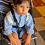 child, toddler, stroller, wizard_hat, mouse_ears, blue_outfit, suspenders, shoes, indoor, floor_tiles, curious, seated, hands, face, brown_hair, cute, young, casual_clothing, baby, portrait