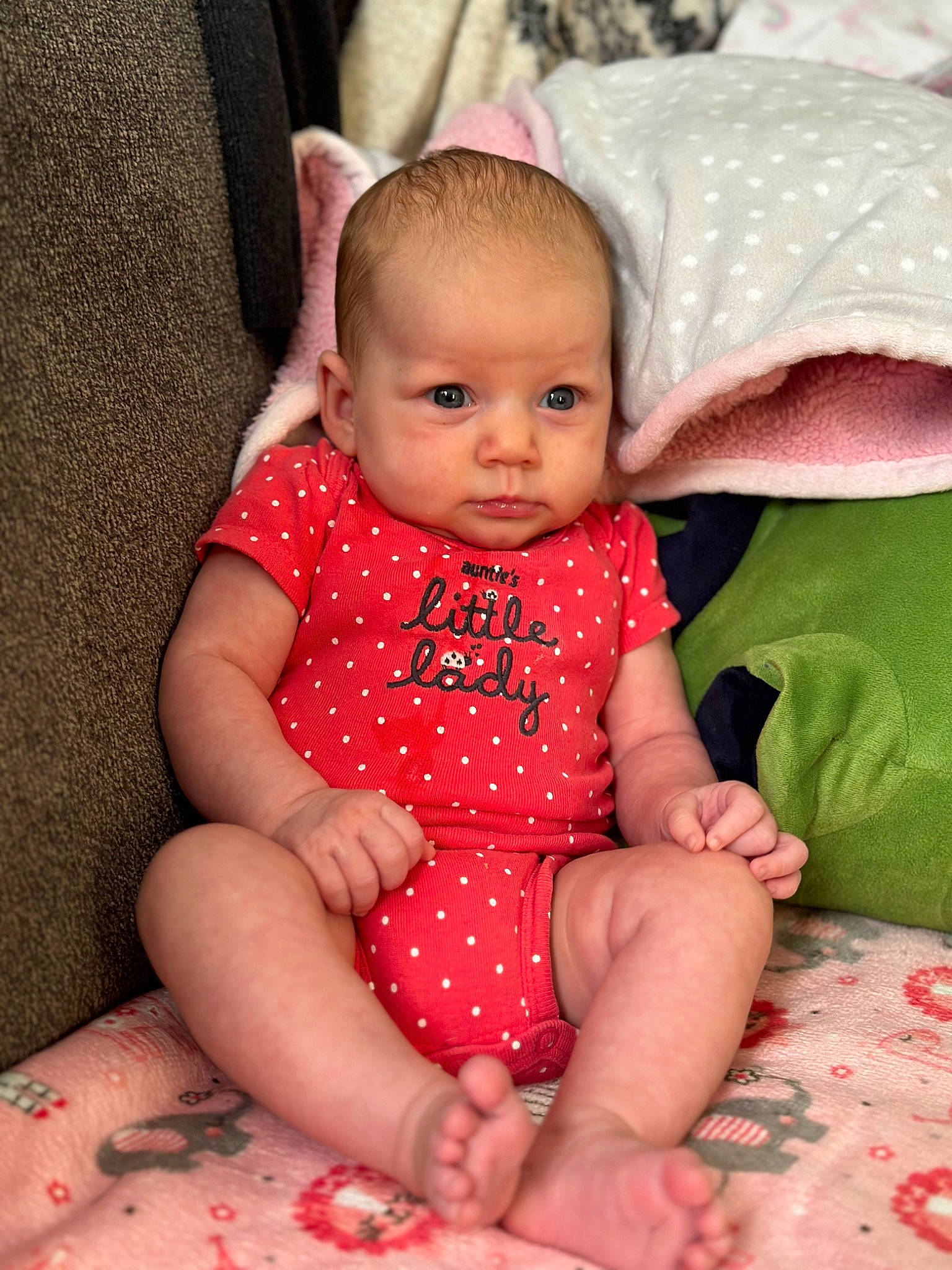 Elizabella is registered to the contest to win money with this photo: baby, baby_toddler_clothing, cheek, child, comfort, finger, happy, human_body, human_leg, iris, lip, mouth, pattern, person, pink, sitting, skin, sleeve, textile, thigh