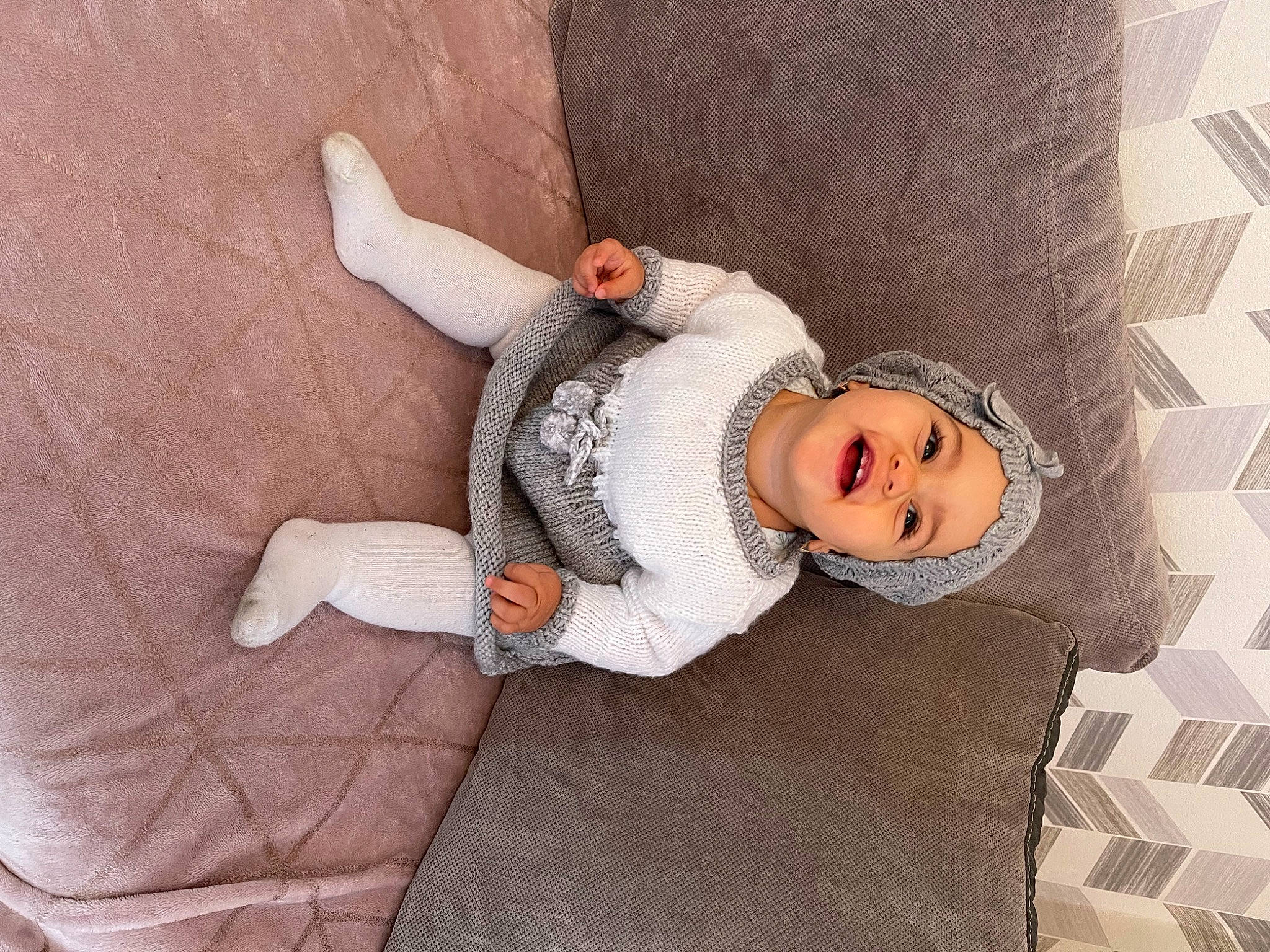 Cléa a rejoint le concours — aidez-le/la à gagner de superbes lots ! baby, baby_products, baby_sleeping, baby_toddler_clothing, child, comfort, fur, headwear, knee, leg, linens, pattern, person, room, sitting, sleeve, smile, textile, thigh, wood