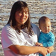 Aaron joined the competition — help win amazing prizes! child, baby, infant, woman, mother, person, portrait, outdoor, lake, ice, snow, mountains, wilderness, nature, landscape, blue_clothing, white_shirt, purple_pants, holding, family