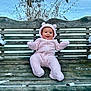 Dayana joined the competition — help win amazing prizes! baby, bear_ears, child, clothing, cold, cute, forest, happy, infant, nature, outdoor, person, pink_onesie, scenery, sitting, smiling, snow, winter, wood, wooden_bench