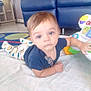 Jaxen is registered to the contest to win money with this photo: baby, child, infant, toy, blanket, blue_couch, carpet, indoor, curious, reaching, clothing, face, floor, comfort, play, young, small, person, cute, expression