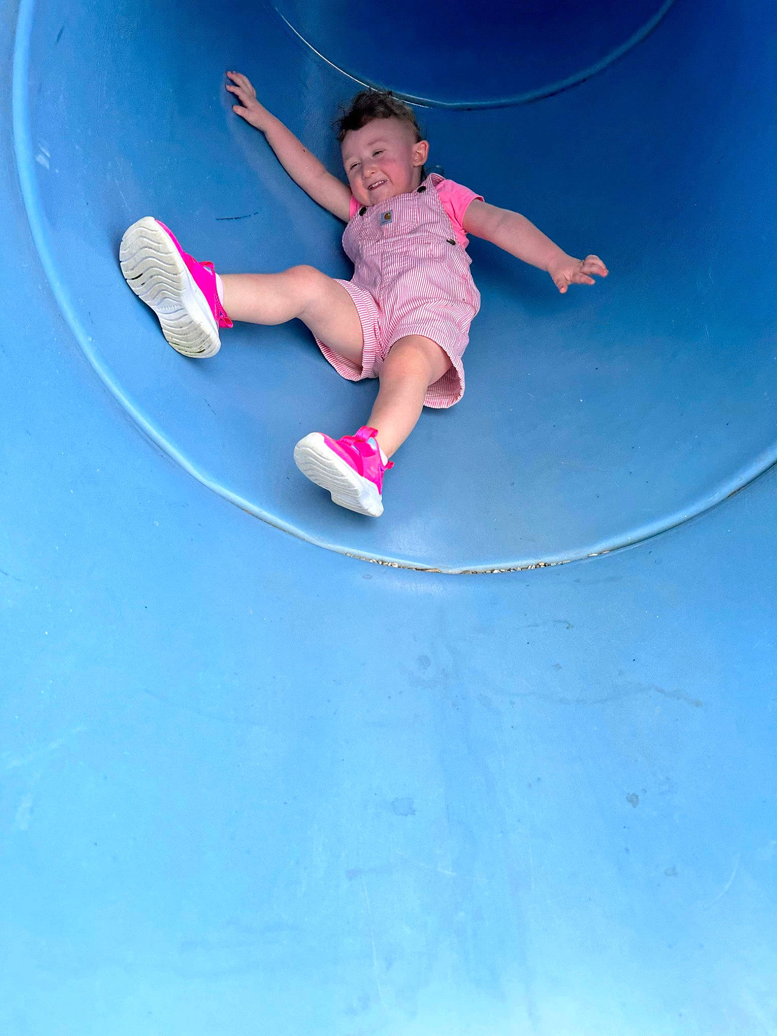 Brylee is registered to the contest to win money with this photo: baby_toddler_clothing, blue, child, concrete, electric_blue, flash_photography, fun, happy, leisure, outdoor_play_equipment, people_in_nature, person, playground, recreation, rolling, sky, slope, sneakers, sports, toddler