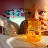 Zito is registered to the contest to win money with this photo: baby, messy, pumpkin_puree, food_jar, high_chair, face, hands, orange_food, infant, child, cute, eating, mealtime, colorful, pattern, indoor, plate, utensil, closeup, portrait
