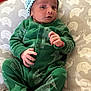 baby, infant, child, green_onesie, hat, cushion, elephant_pattern, indoor, portrait, newborn, cute, clothing, sleepwear, lying_down, small_hands, soft_fabric, face, headwear, baby_bed, resting