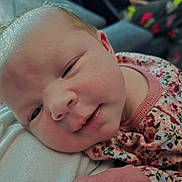 Tina joined the competition — help win amazing prizes! baby, newborn, close_up, face, infant, sleepy, resting, pink_clothing, floral_pattern, soft_skin, portrait, child, cute, peaceful, indoor, human, person, young, head, expression