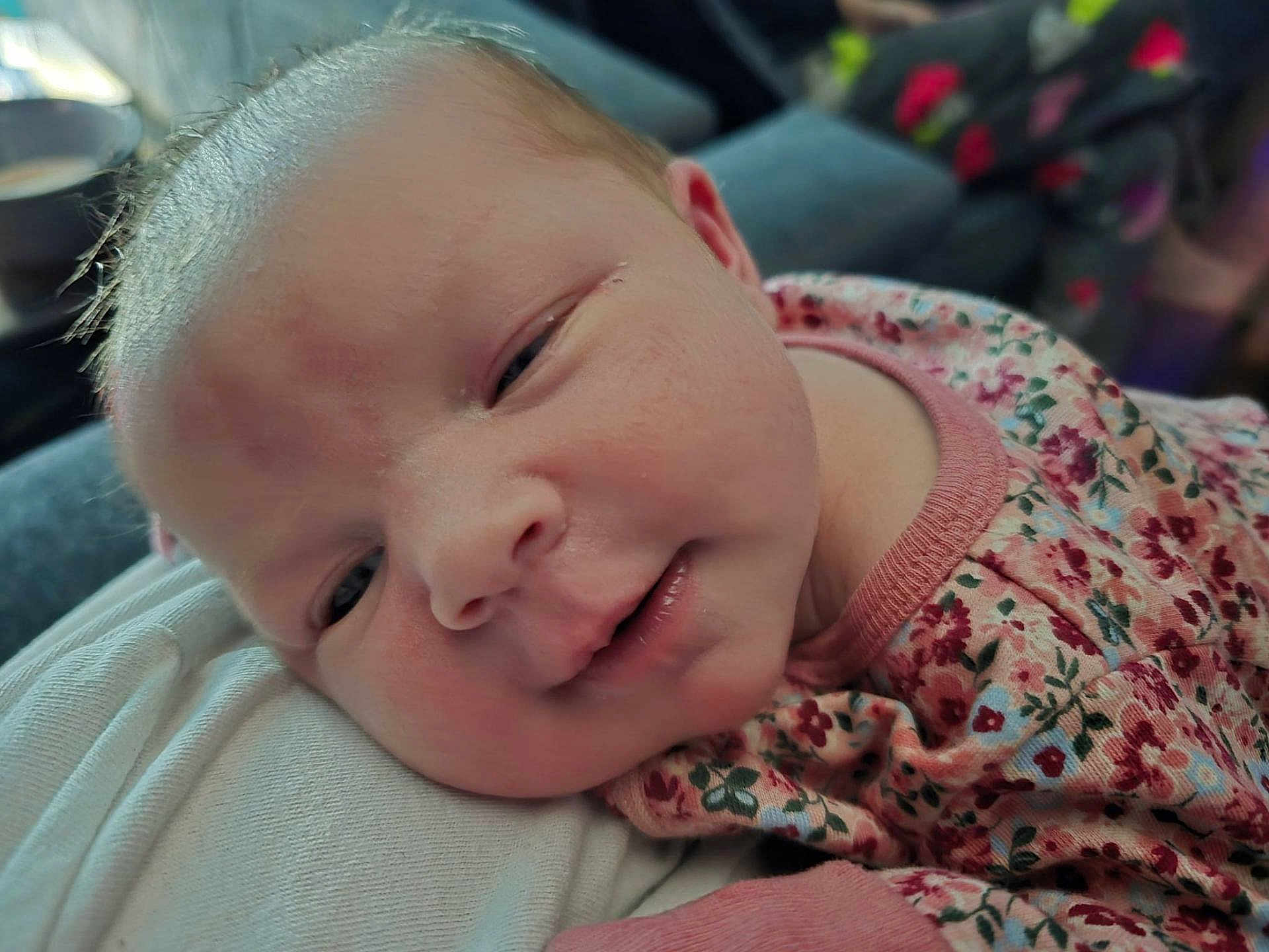 Tina joined the competition — help win amazing prizes! baby, newborn, close_up, face, infant, sleepy, resting, pink_clothing, floral_pattern, soft_skin, portrait, child, cute, peaceful, indoor, human, person, young, head, expression