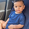 toddler, child, car_seat, blue_clothing, nike_logo, sitting, indoors, vehicle_interior, short_hair, barefoot, portrait, young_child, looking_at_camera, casual, relaxed, cute, small_person, young_boy, seatbelt, daylight