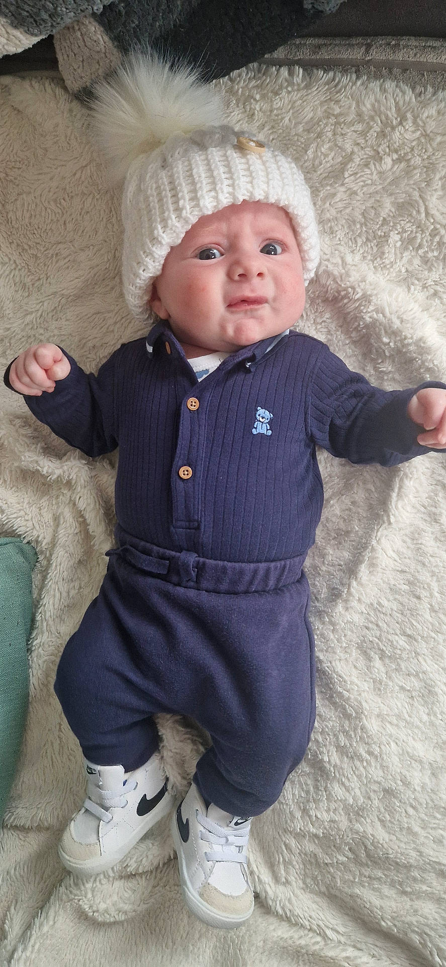 Theo is registered to the contest to win money with this photo: baby, beanie, bodypart, bonnet, cap, clothing, face, finger, footwear, hat, head, jeans, knitwear, newborn, pants, person, photography, portrait, shoe, sweater