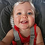 baby, child, smiling, high_chair, red_clothing, polka_dot, face, blue_eyes, teeth, curly_hair, straps, indoor, close_up, happy, cute, infant, person, skin, mouth, portrait