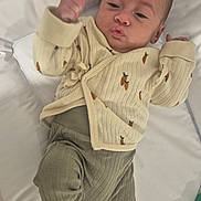 Mélaëlle a rejoint le concours — aidez-le/la à gagner de superbes lots ! baby, infant, child, lying_down, clothing, cardigan, pants, carrot_print, cute, expression, face, raised_arm, blanket, cushion, soft_surface, indoors, foot, hand, baby_wipes, playful