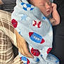 Tyler joined the competition — help win amazing prizes! newborn, baby, blanket, sleeping, hand, person, plaid, sports_pattern, football, basketball, baseball, cozy, infant, wrapped, soft_texture, rest, car_seat, phone, casual_clothing, indoor