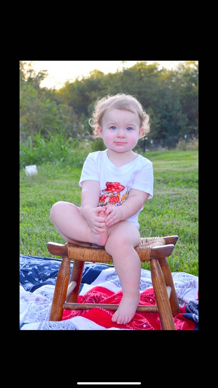 Veronica is registered to the contest to win money with this photo: chair, child, flash_photography, fun, grass, happy, human_leg, lap, leisure, magenta, people_in_nature, person, plant, recreation, shorts, sitting, smile, summer, t_shirt, toddler