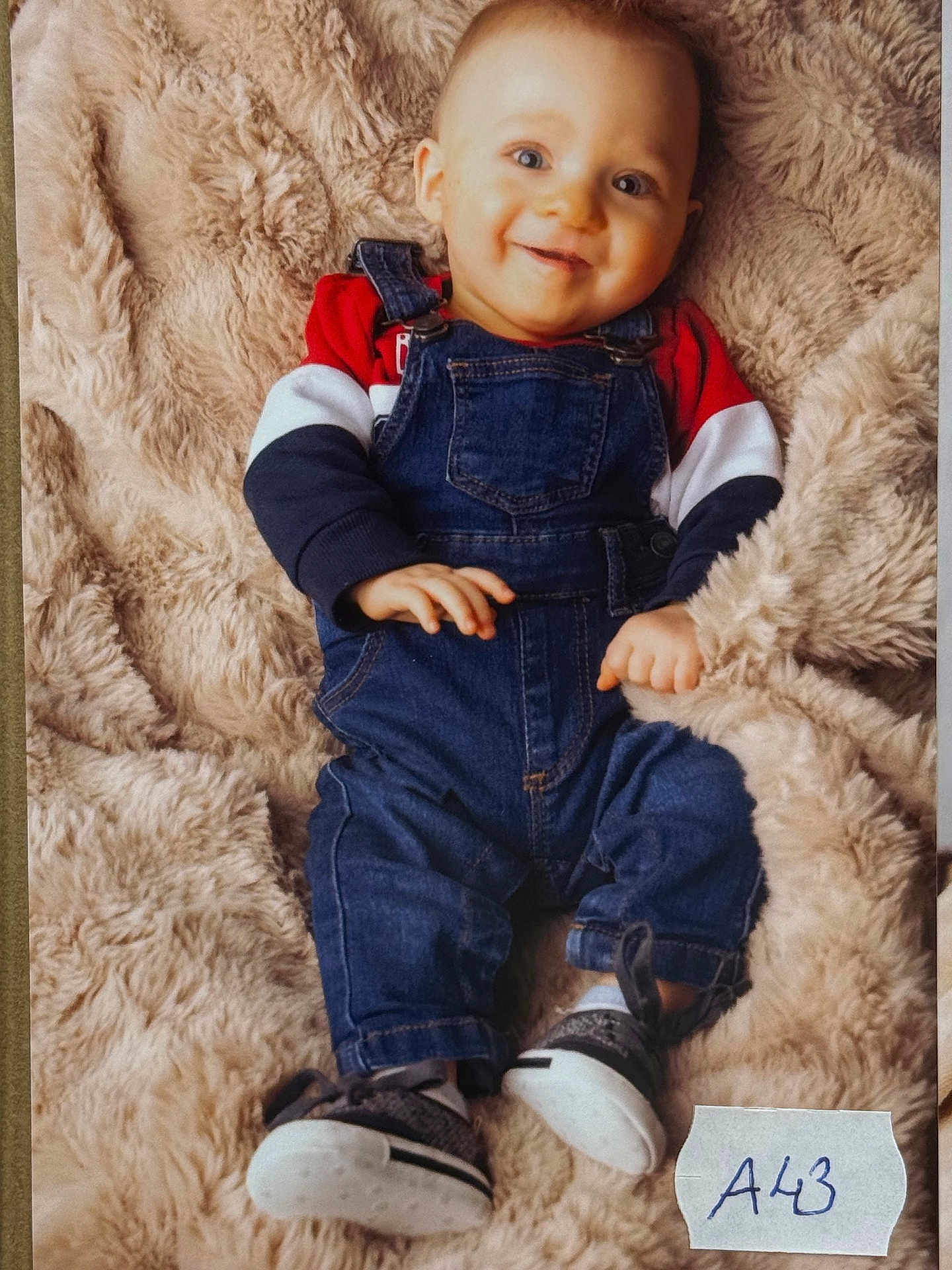 Thyliam participe au concours pour gagner de l'argent avec cette photo : baby, child, smiling, denim_overalls, long_sleeve_shirt, blue_eyes, blanket, soft_texture, sitting, footwear, casual_clothing, happy, infant, portrait, indoor, cute, young_child, cozy, person, fashion