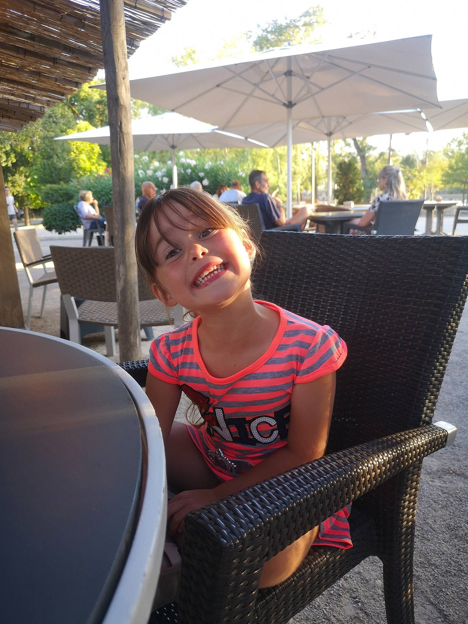 Ambre a rejoint le concours — aidez-le/la à gagner de superbes lots ! chair, event, fun, grass, happy, joy, leisure, outdoor_furniture, outdoor_table, person, recreation, shade, sitting, smile, t_shirt, toddler, tourism, travel, tree, umbrella