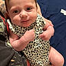 Anluisa joined the competition — help win amazing prizes! baby, infant, smile, face, arm, hand, tattoo, clothing, pattern, fabric, person, cute, skin, holding, portrait, indoors, child, human, apparel, sleeveless