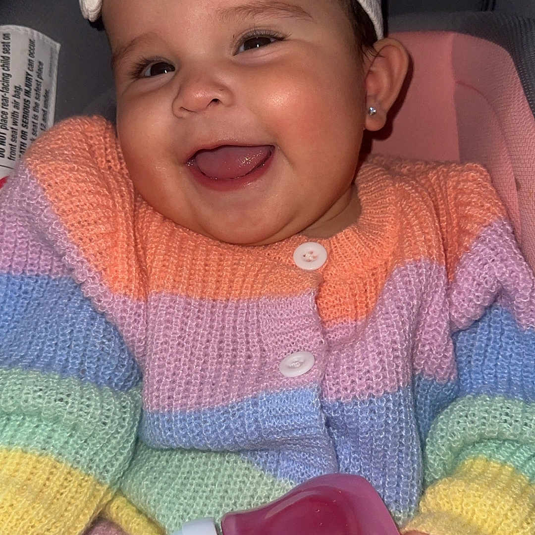 Betzabel joined the competition — help win amazing prizes! accessories, baby, beverage, bodypart, cap, clothing, couch, face, finger, furniture, hand, happy, hat, head, knitwear, person, photography, portrait, smile, sweater