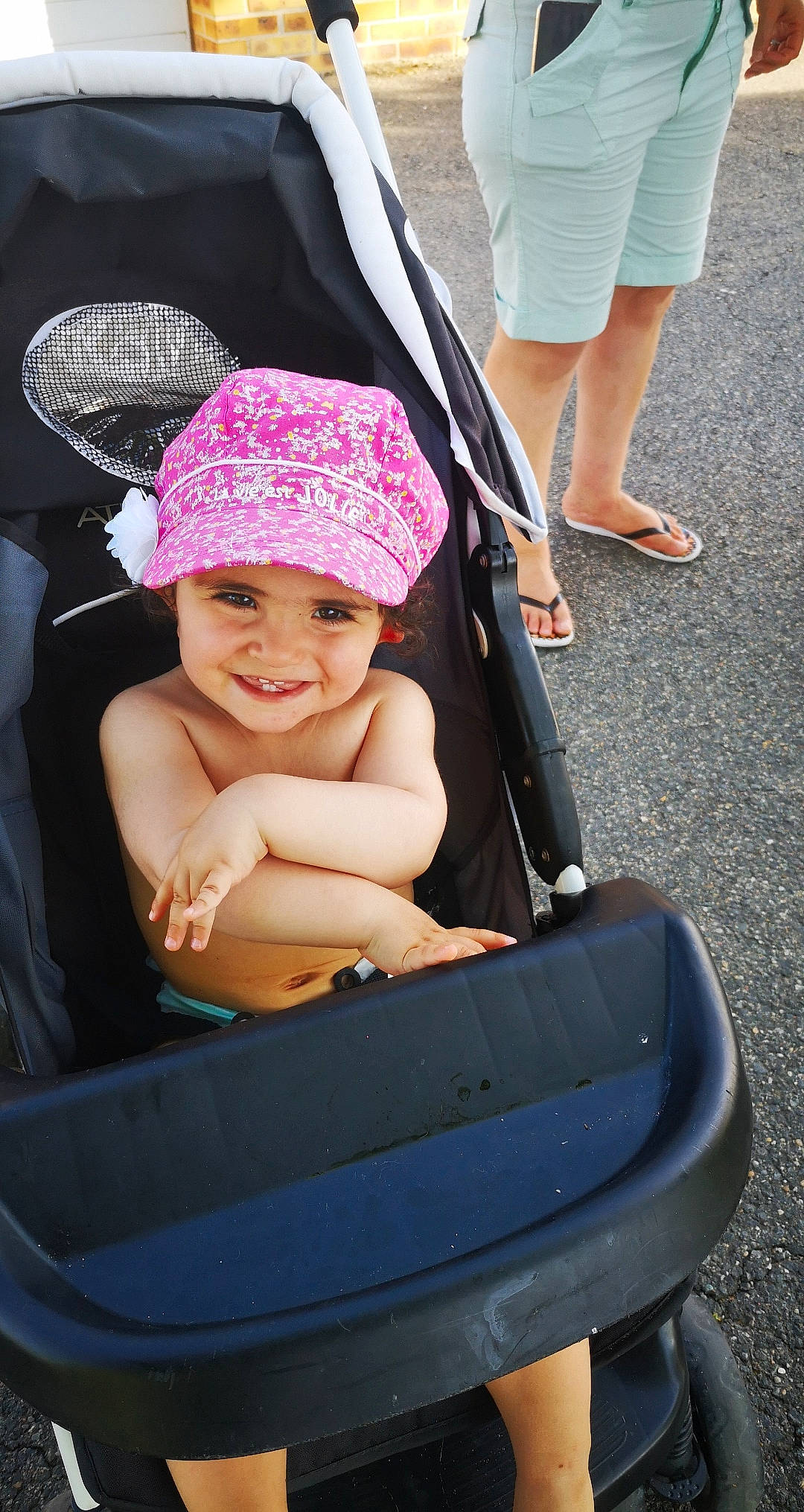 Yusra a rejoint le concours — aidez-le/la à gagner de superbes lots ! baby, baby_carriage, baby_products, bonnet, cap, child, diaper_bag, fun, hat, headgear, headwear, joy, person, pink, product, sitting, smile, sun_hat, toddler, vacation