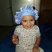 Ivy joined the competition — help win amazing prizes! toddler, child, smiling, bonnet, pajamas, leopard_print, indoor, blanket, lamp, furniture, room, happy, person, portrait, seated, headwear, cute, young_child, cozy, home