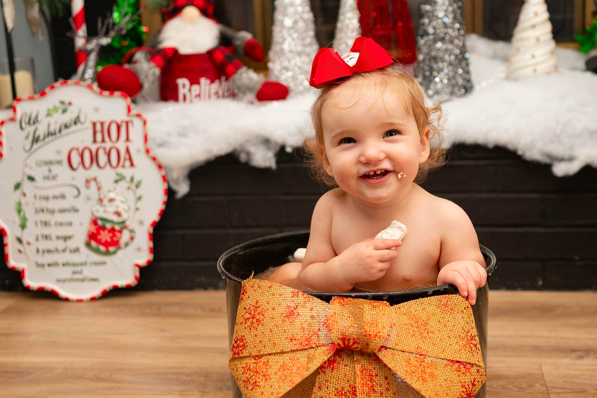 Ariel is registered to the contest to win money with this photo: baby, baby_toddler_clothing, child, christmas_decoration, christmas_ornament, costume_hat, event, facial_expression, fun, green, happy, holiday, joy, ornament, person, red, santa_claus, smile, toddler, tradition