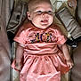 baby, infant, child, smiling, dress, peach, pacifier, seat, cushion, comfort, tongue_out, cute, happy, clothing, person, indoor, closeup, skin, face, babywear