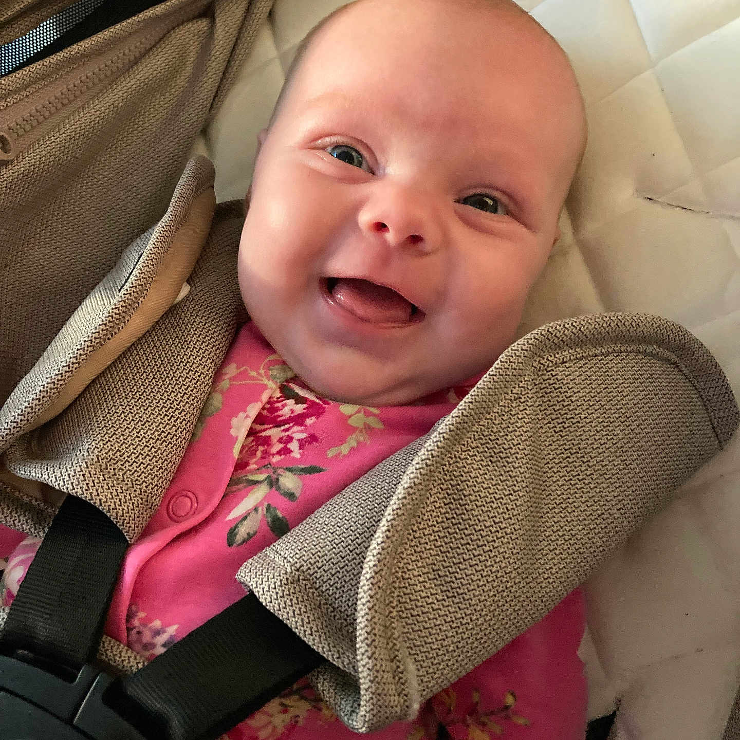 Ava is registered to the contest to win money with this photo: apparel, baby, car_seat, child, closeup, comfort, cute, face, floral, happy, indoors, infant, joyful, person, pink_clothing, portrait, seat, smiling, straps, young