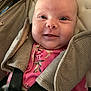 Ava is registered to the contest to win money with this photo: baby, infant, smile, car_seat, harness, pink_clothing, floral_pattern, face, child, cute, young, person, seat_belt, closeup, expression, happy, indoors, fabric, head, skin