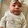Ava joined the competition — help win amazing prizes! baby, infant, child, face, headband, bow, clothing, onesie, ribbed_fabric, hearts, message, portrait, cute, expression, indoors, soft_focus, skin, happy, small_hand, looking_up