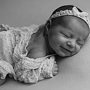 Ambre a rejoint le concours — aidez-le/la à gagner de superbes lots ! newborn, baby, sleeping, smiling, headband, ruffled_clothing, black_and_white, soft_texture, portrait, closeup, infant, peaceful, cute, resting, child, delicate, adorable, young, face, toddler