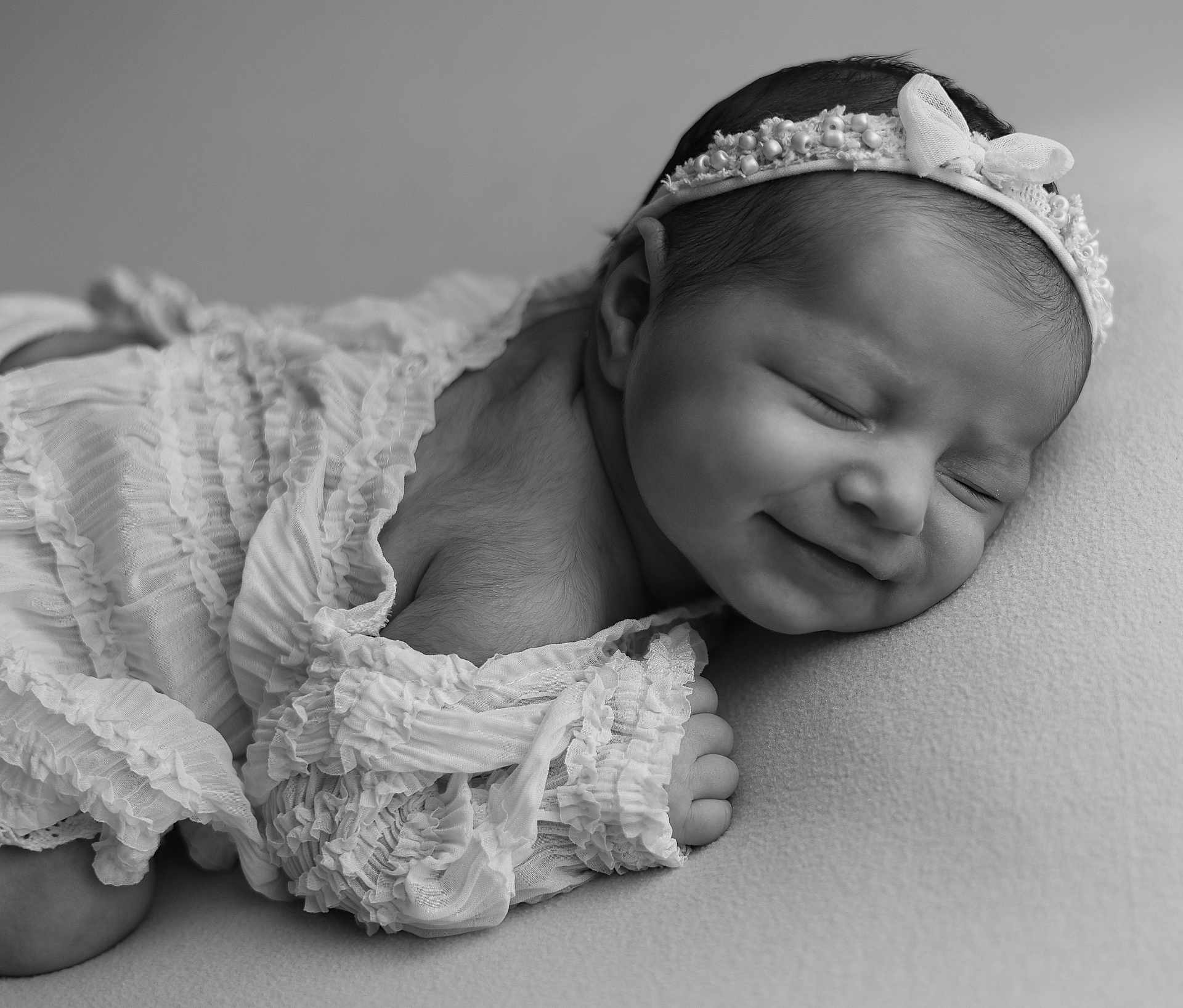 Ambre a rejoint le concours — aidez-le/la à gagner de superbes lots ! newborn, baby, sleeping, smiling, headband, ruffled_clothing, black_and_white, soft_texture, portrait, closeup, infant, peaceful, cute, resting, child, delicate, adorable, young, face, toddler