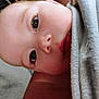 baby, close_up, face, blanket, soft_texture, skin, eyes, infant, portrait, indoors, young_child, head, curious, wrapped, cozy, human, person, cute, tender, expression