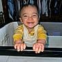 baby, child, smile, happy, playpen, clothing, indoor, person, hands, face, closet, furniture, yellow, white, long_sleeve, cute, infant, portrait, babywear, home