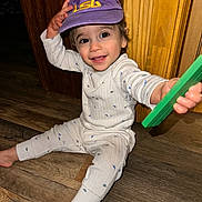 Colton joined the competition — help win amazing prizes! cap, child, cute, dinosaur_pattern, face, floor, hand, happy, hat, indoor, lsu, pajamas, person, reaching, sitting, smiling, toddler, toy, wood_floor, young_child