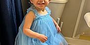 Wren joined the competition — help win amazing prizes! toddler, child, blue_dress, flower_headband, smiling, toilet, bathroom, barefoot, curtain, wood_floor, person, happy, young_child, indoor, headband, dressed_up, cute, sitting, small_child, playful