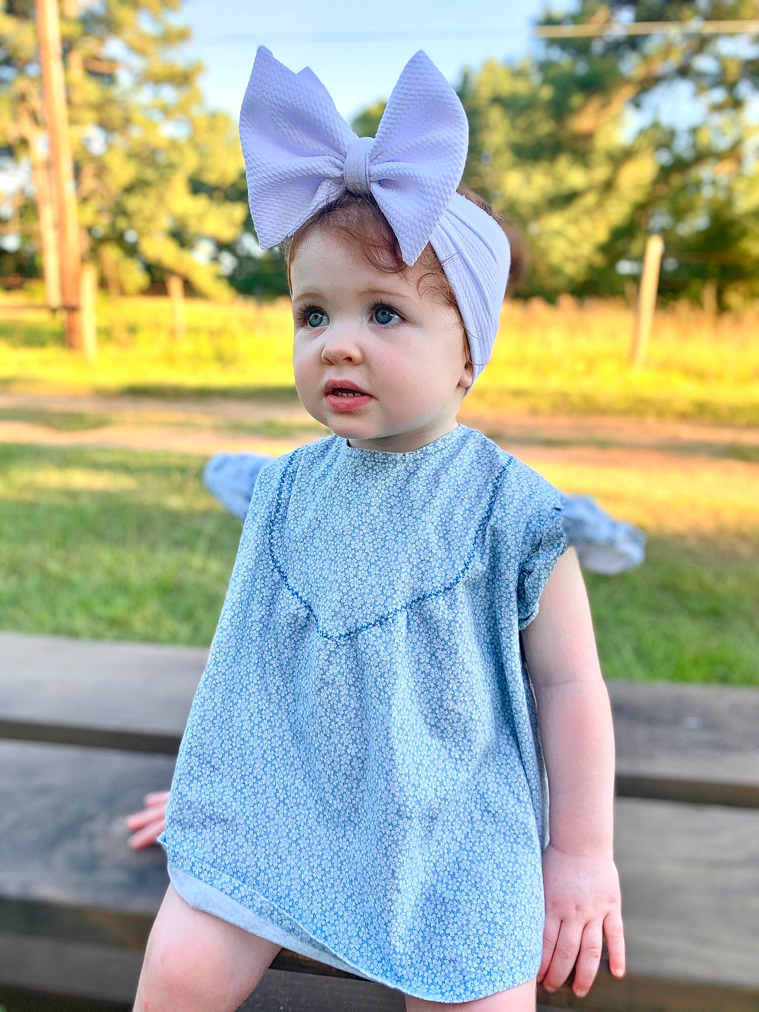 Adley is registered to the contest to win money with this photo: baby, baby_toddler_clothing, cap, child, costume_hat, electric_blue, eye, grass, happy, headwear, outerwear, pattern, person, pink, plant, purple, sky, sleeve, street_fashion, t_shirt