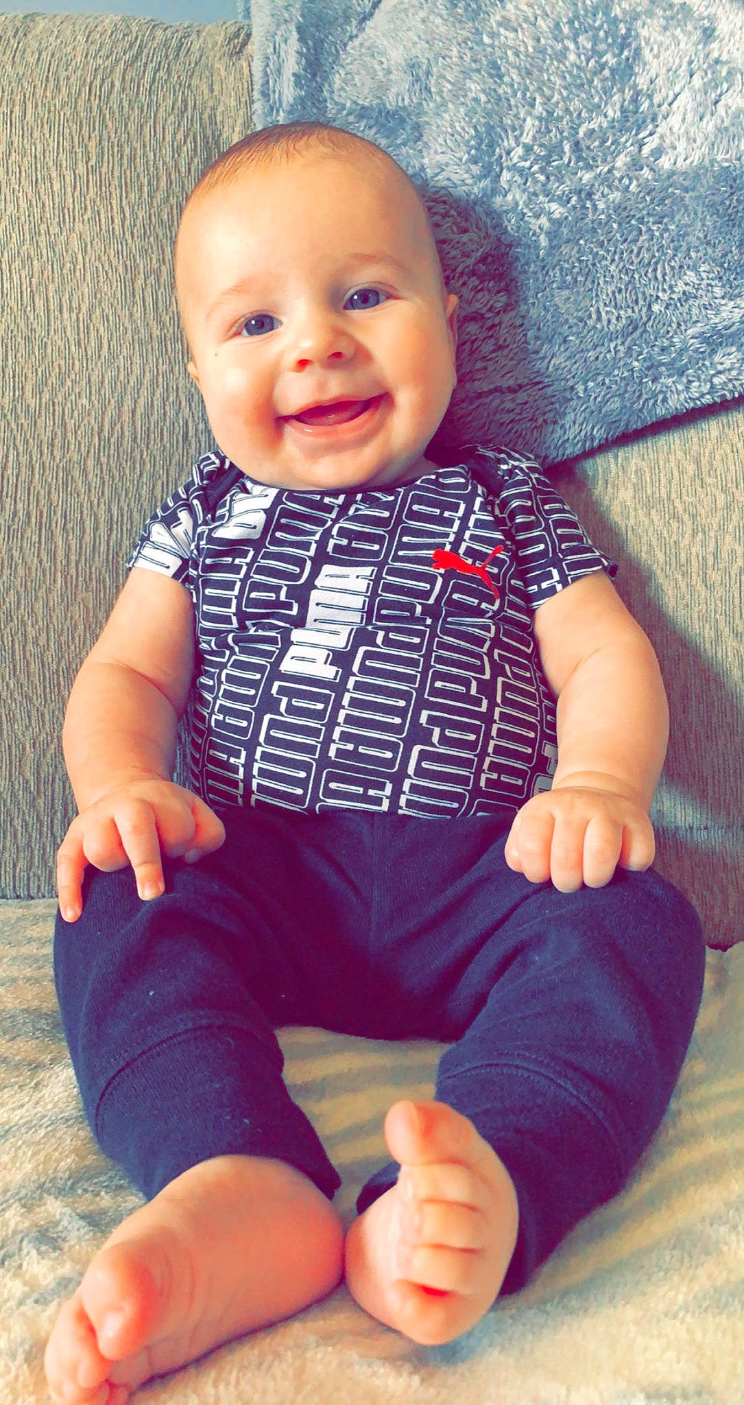 Kenton is registered to the contest to win money with this photo: azure, baby, baby_toddler_clothing, blue, cheek, cool, eye, face, finger, happy, head, iris, joy, person, photograph, skin, sleeve, smile, standing, t_shirt