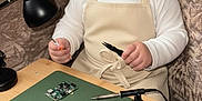 Syed Masoom is registered to the contest to win money with this photo: baby, child, goggles, apron, table, electronics, circuit_board, soldering_iron, lamp, couch, indoor, curious, tinkering, technology, tools, small_table, seated, person, closeup, cozy