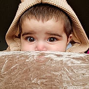 Syed Masoom is registered to the contest to win money with this photo: child, toddler, face, eyes, knitted_hood, ears, blanket, soft_texture, brown, cute, peek, cozy, portrait, indoor, closeup, expression, warm, baby, hood, curious