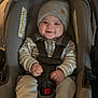 Jasper is registered to the contest to win money with this photo: baby, child, car_seat, hat, smiling, straps, cozy, indoor, clothing, infant, seat, cute, comfort, knit_hat, person, young_child, sitting, happy, safety, casual