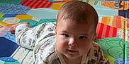 Jasper joined the competition — help win amazing prizes! baby, child, pajamas, playmat, colorful, indoor, floor, wooden_cabinet, toy, pattern, curious, lying_down, cheeks, face, infant, cute, home, soft_lighting, person, young_child