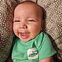 Mason joined the competition — help win amazing prizes! baby, smiling, green_shirt, patterned_cushion, close_up, happy, infant, cute, portrait, child, face, joyful, clothing, indoor, soft_lighting, young_child, sitting, lizard_print, cushion, comfortable