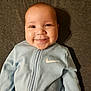 Mason joined the competition — help win amazing prizes! baby, smile, face, infant, clothing, nike_logo, blue_outfit, happy, cute, portrait, child, young, sleeper, lying_down, indoors, closeup, head, skin, person, apparel