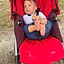 Louca a rejoint le concours — aidez-le/la à gagner de superbes lots ! toddler, stroller, outdoor, child, red, grass, gravel, foot, holding, casual_clothing, parked_car, wheel, seat, person, baby, expression, daylight, nature, sidewalk, resting
