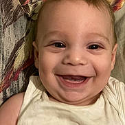 Louca participe au concours pour gagner de l'argent avec cette photo : baby, babyclothes, child, closeup, cute, expression, eyes, fabric, face, happy, head, indoors, infant, lying, person, portrait, skin, smile, teeth, young