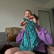 Louca a rejoint le concours — aidez-le/la à gagner de superbes lots ! baby, child, adult, laughing, smiling, dress, purple_hoodie, couch, blanket, living_room, indoor, person, happy, playful, seated, holding, joy, casual, home, fun