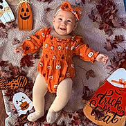 Serayah is registered to the contest to win money with this photo: baby, infant, orange_clothing, headband, smiling, blanket, autumn_leaves, halloween, pumpkin, ghost, decorations, milestone_sign, tights, cute, festive, holiday, lying_down, indoor, seasonal, person