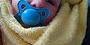 Marcus is registered to the contest to win money with this photo: baby, blanket, carpet, child, closeup, comfort, cute, expression, face, human, indoor, infant, newborn, pacifier, pattern, portrait, soft_texture, warm, wrapped, yellow