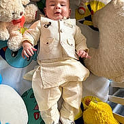 Huraira Muhammad is registered to the contest to win money with this photo: baby, child, infant, plush_toy, stuffed_animal, bed, blanket, clothing, footwear, person, indoors, cute, smile, portrait, soft_toy, decor, lying_down, fabric, colorful, comfortable